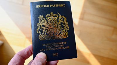 A person holding a new style British passport.