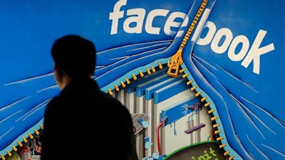 FILE - A man walks past a mural in an office on the Facebook campus in Menlo Park, Calif., June 11, 2014. A once-ambitious but now faltering Facebook-backed digital currency project known as Diem, formerly known as Libra, is dead and its assets sold to bank holding company Silvergate Capital. (AP Photo/Jeff Chiu, File)