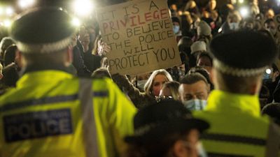 A woman holds up a placard as people gather in Clapham Common, London, after the Reclaim These Streets vigil for Sarah Everard was officially cancelled.