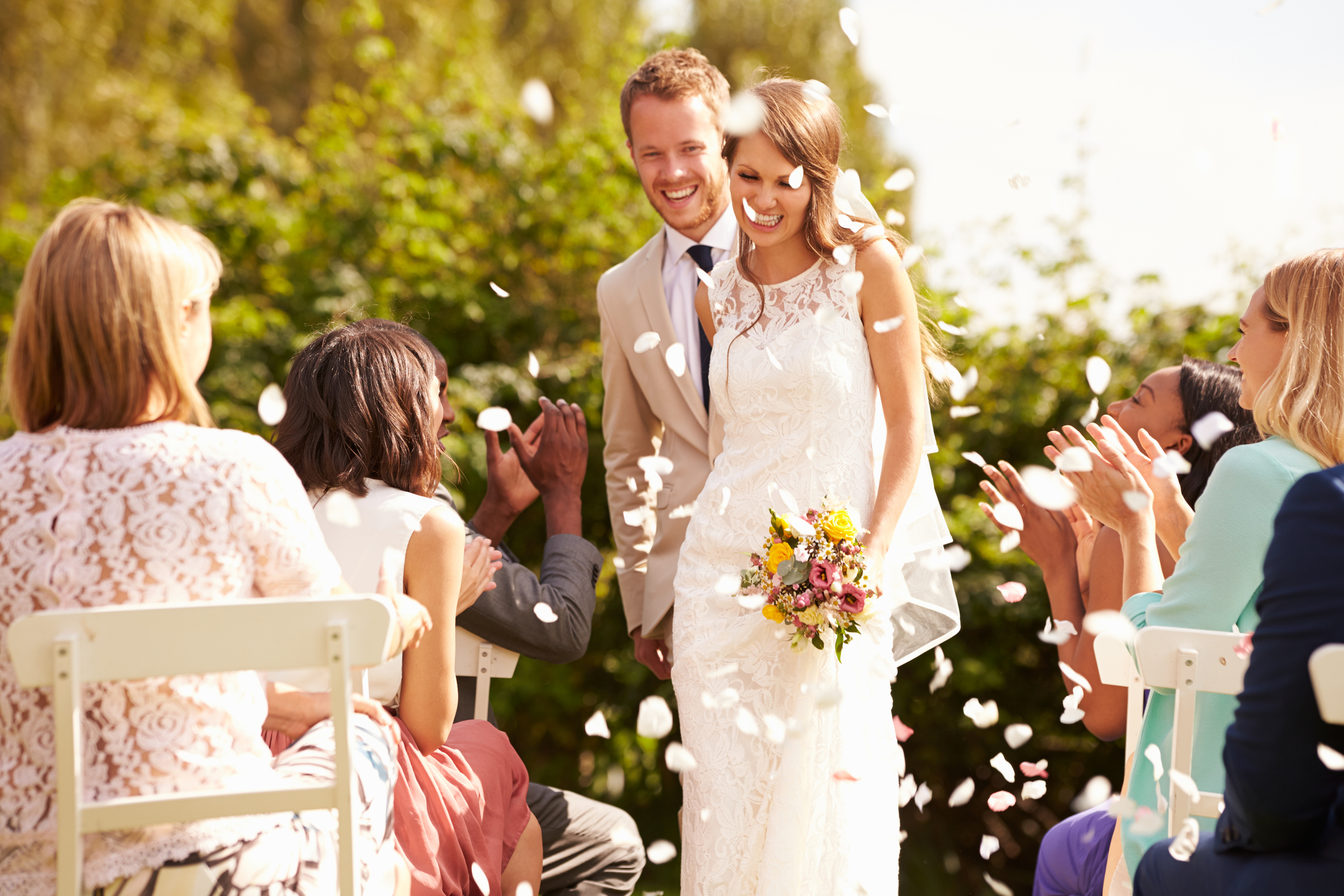 Wedding guests applaud the newlyweds