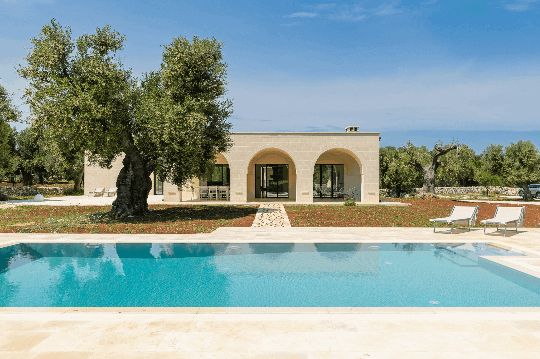View of Trullo Cillini, a villa in Carovigno managed by Wonderful Italy, from the outside with swimming pool. 