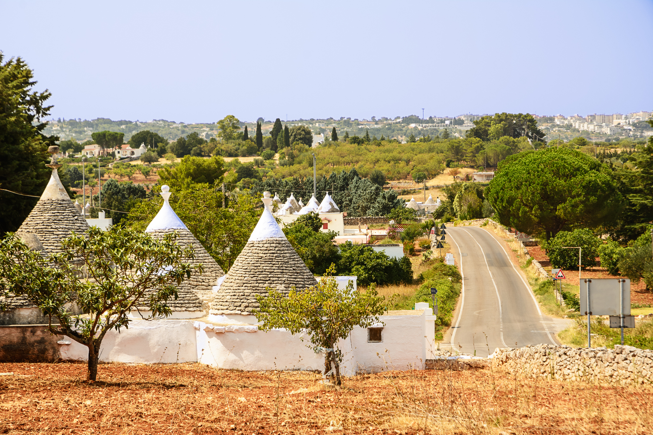 Scorcio della campagna pugliese con un gruppo di trulli in primo piano