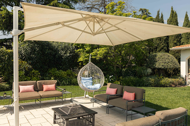 The private garden of a villa on Lake Garda with umbrella, coffee table and armchairs