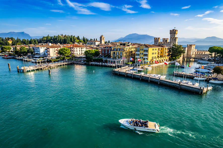 The port of Sirmione seen from above with a boat passing through it