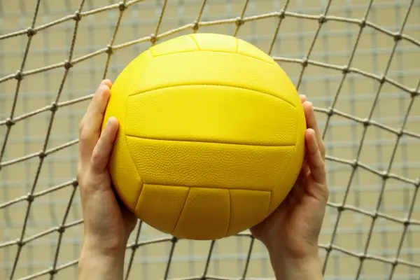 holding yellow volleyball