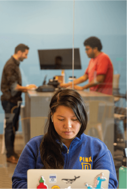 Women on computer with people in the background