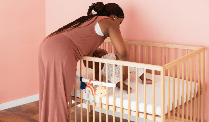 Parent putting their baby into a crib