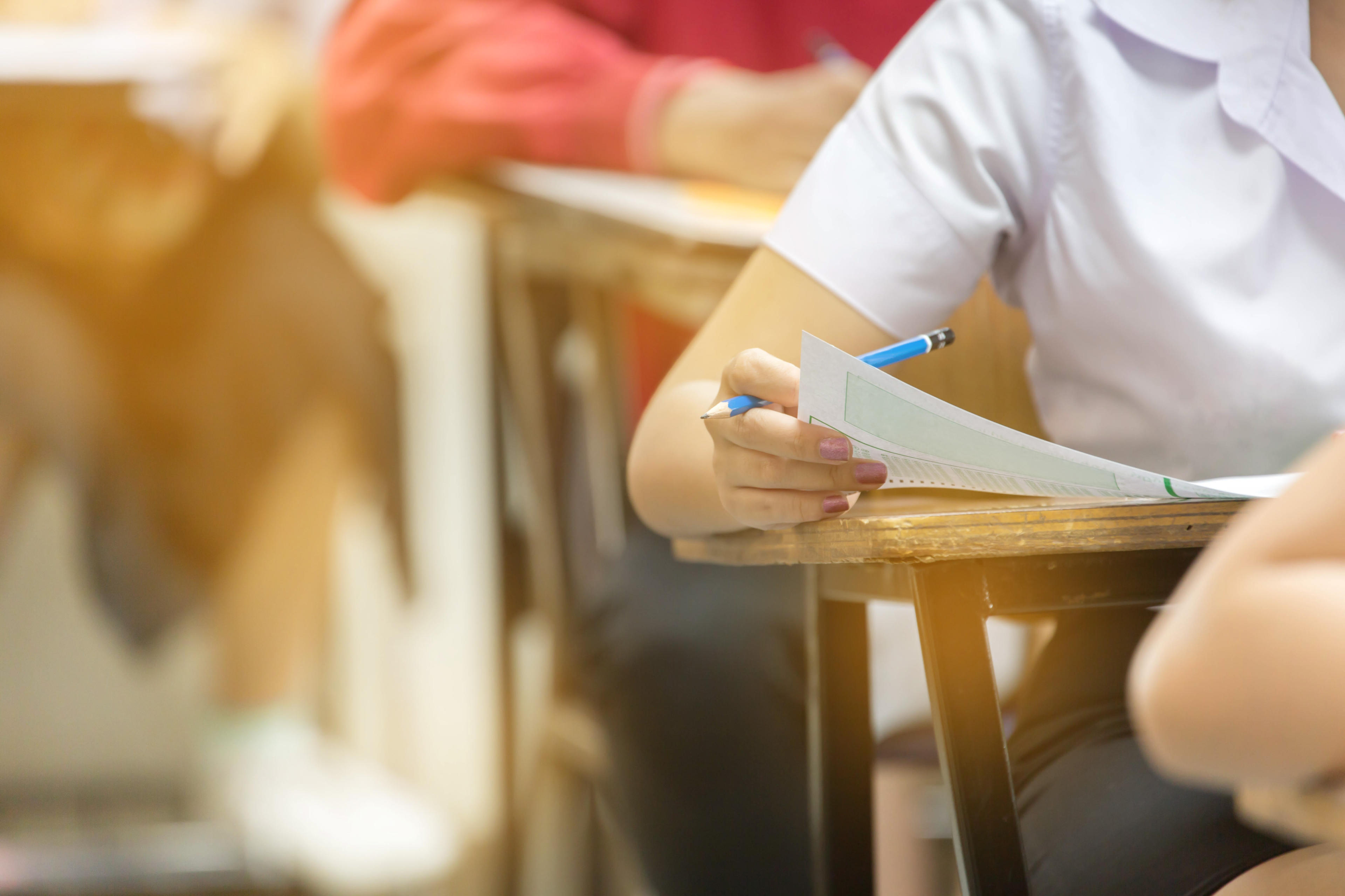 An image of a pupil at a desk with pencil and paper