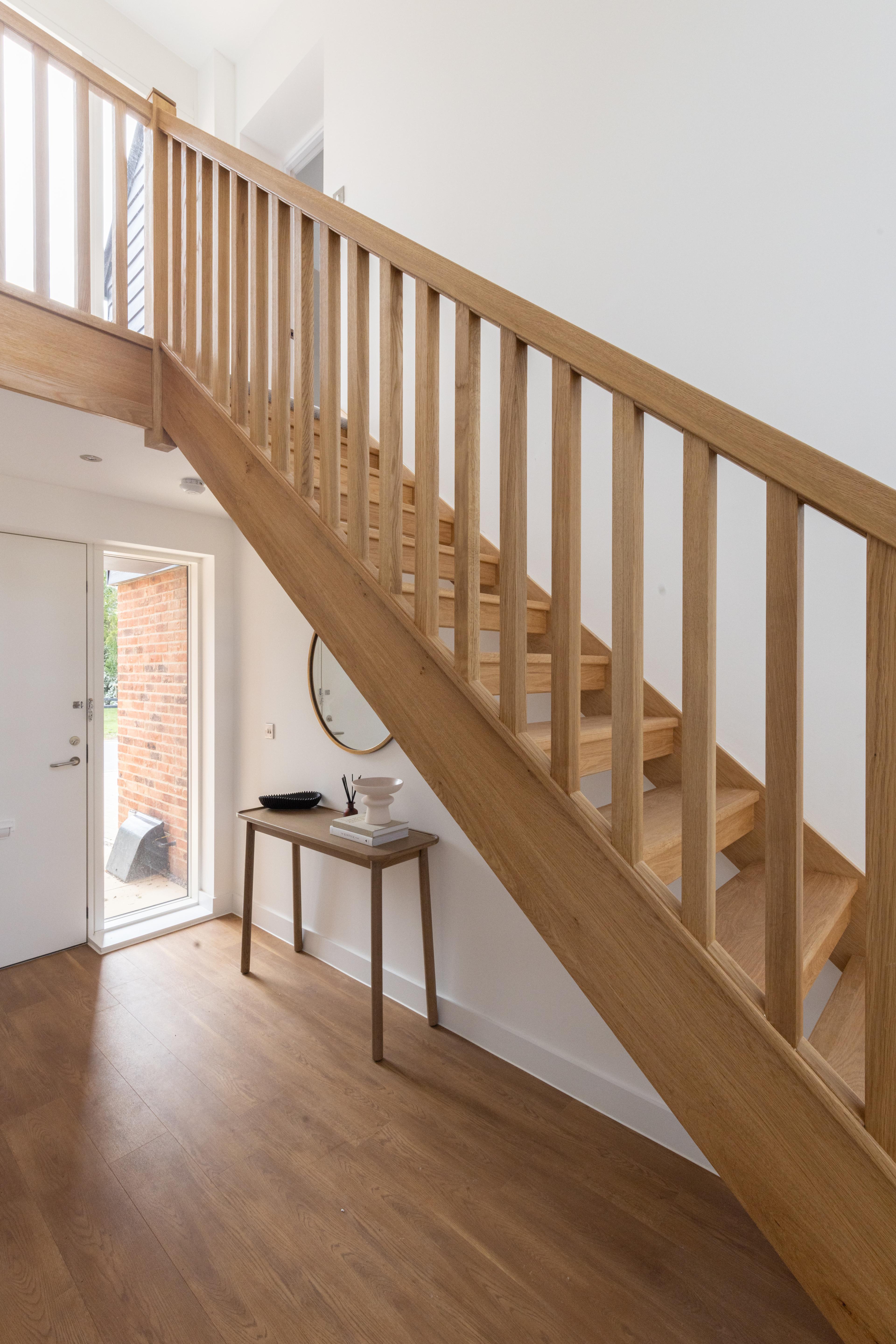 Stairs leasing upstairs with a desk underneath