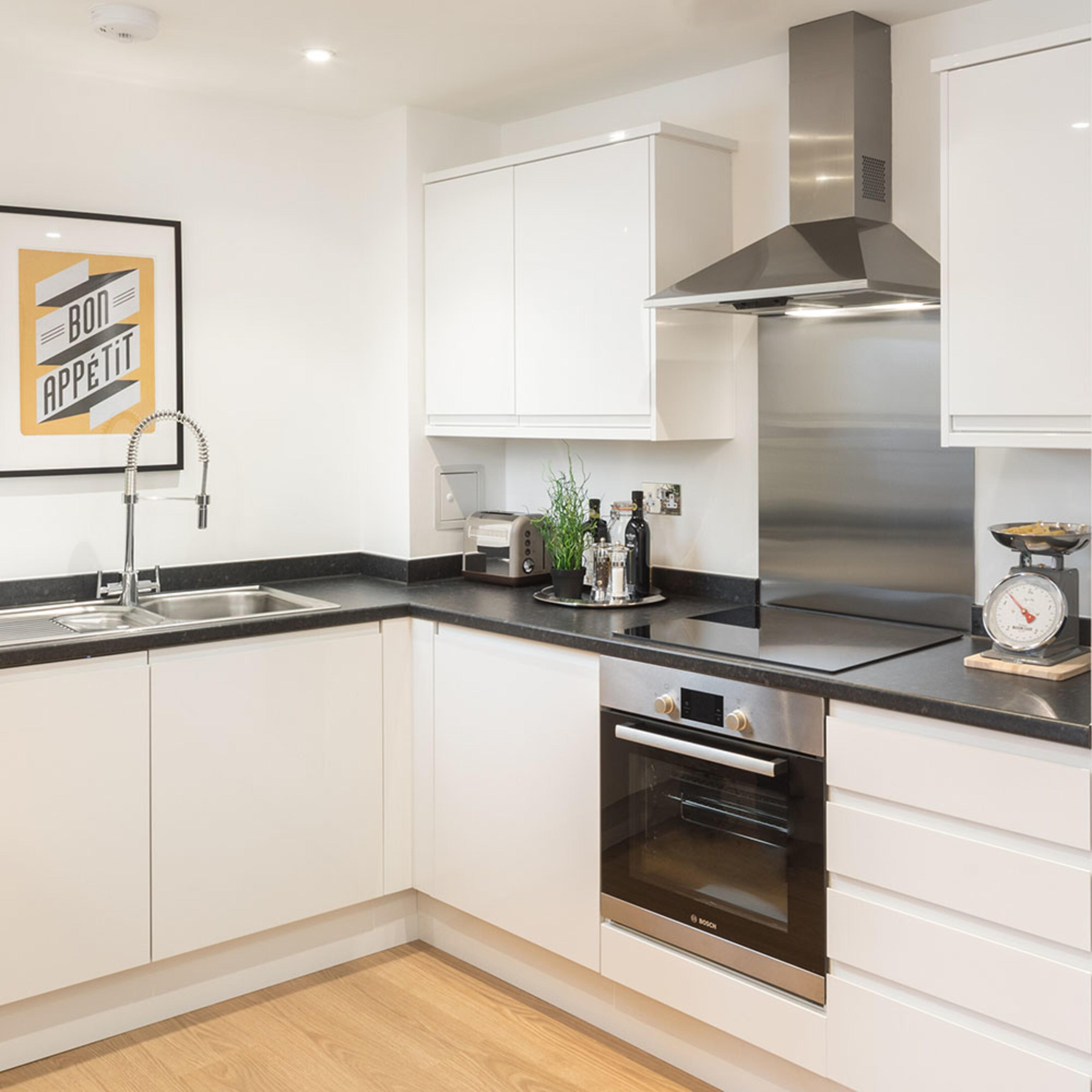 persona-homes-specification-kitchen-white-units-black-worktops-laminate-floor-bosch-oven-steel hood-