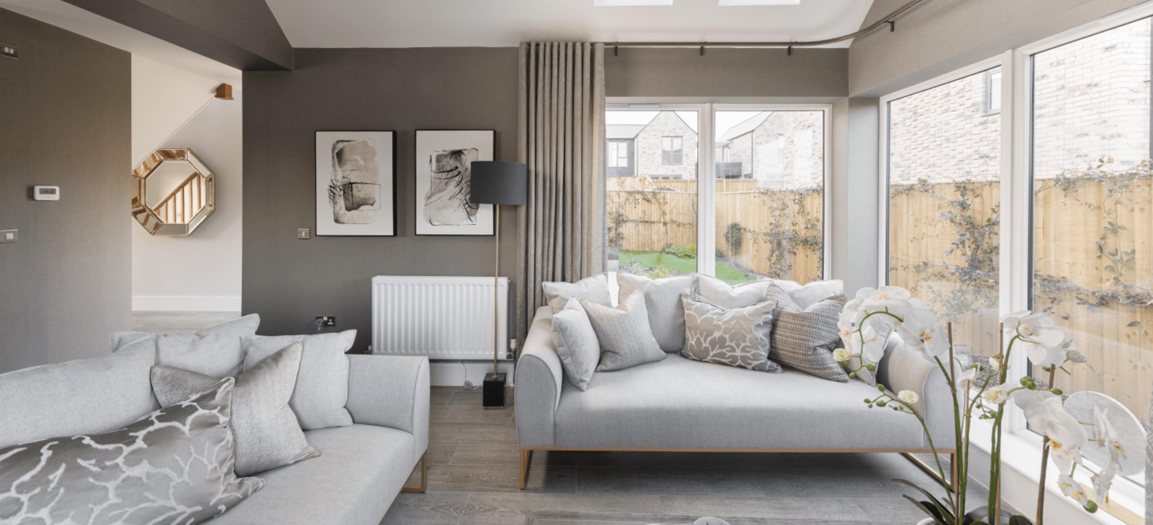 living room with two grey sofas with large windows looking into garden