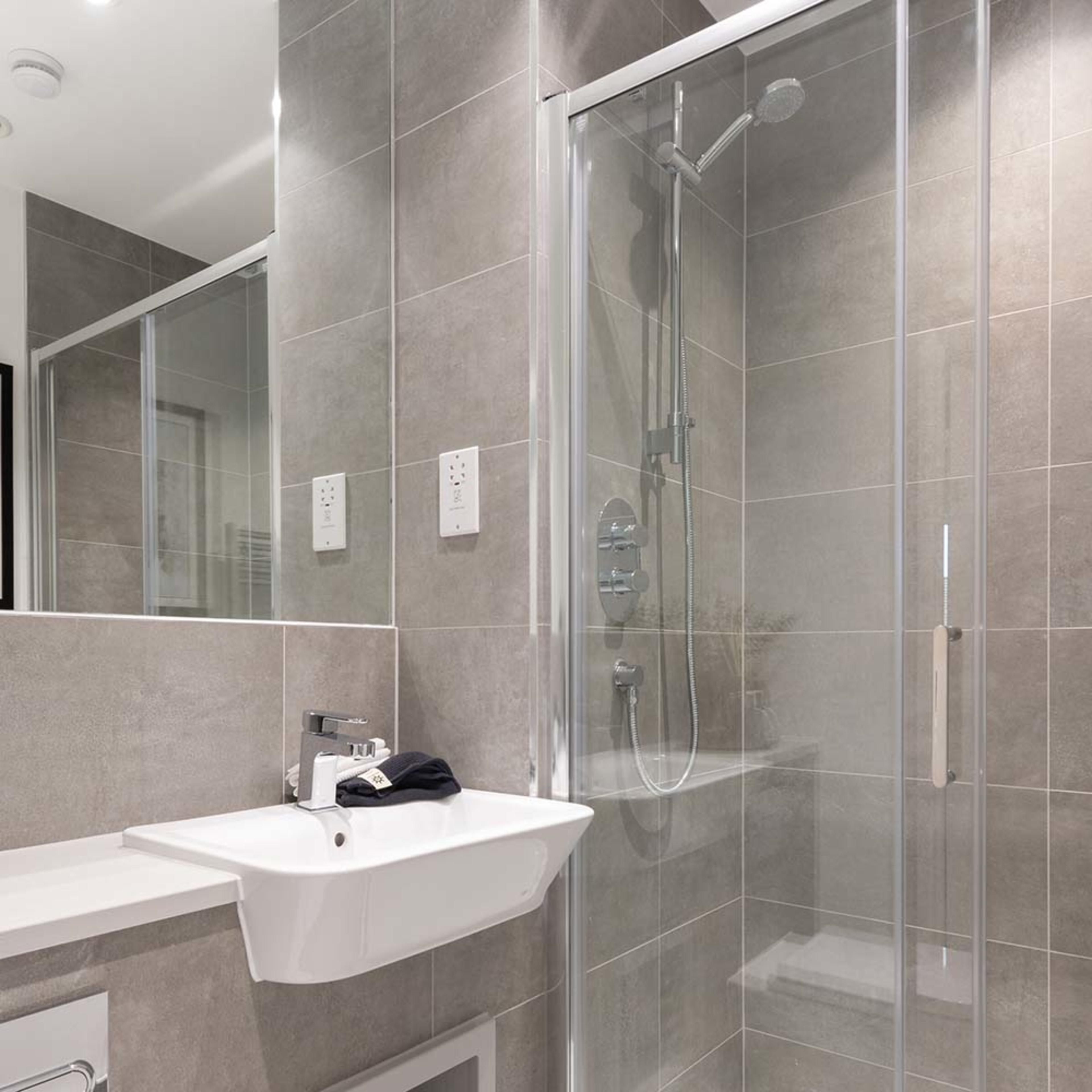 persona-homes-specification-bathroom-shower-room-dark-tiles-white-sink