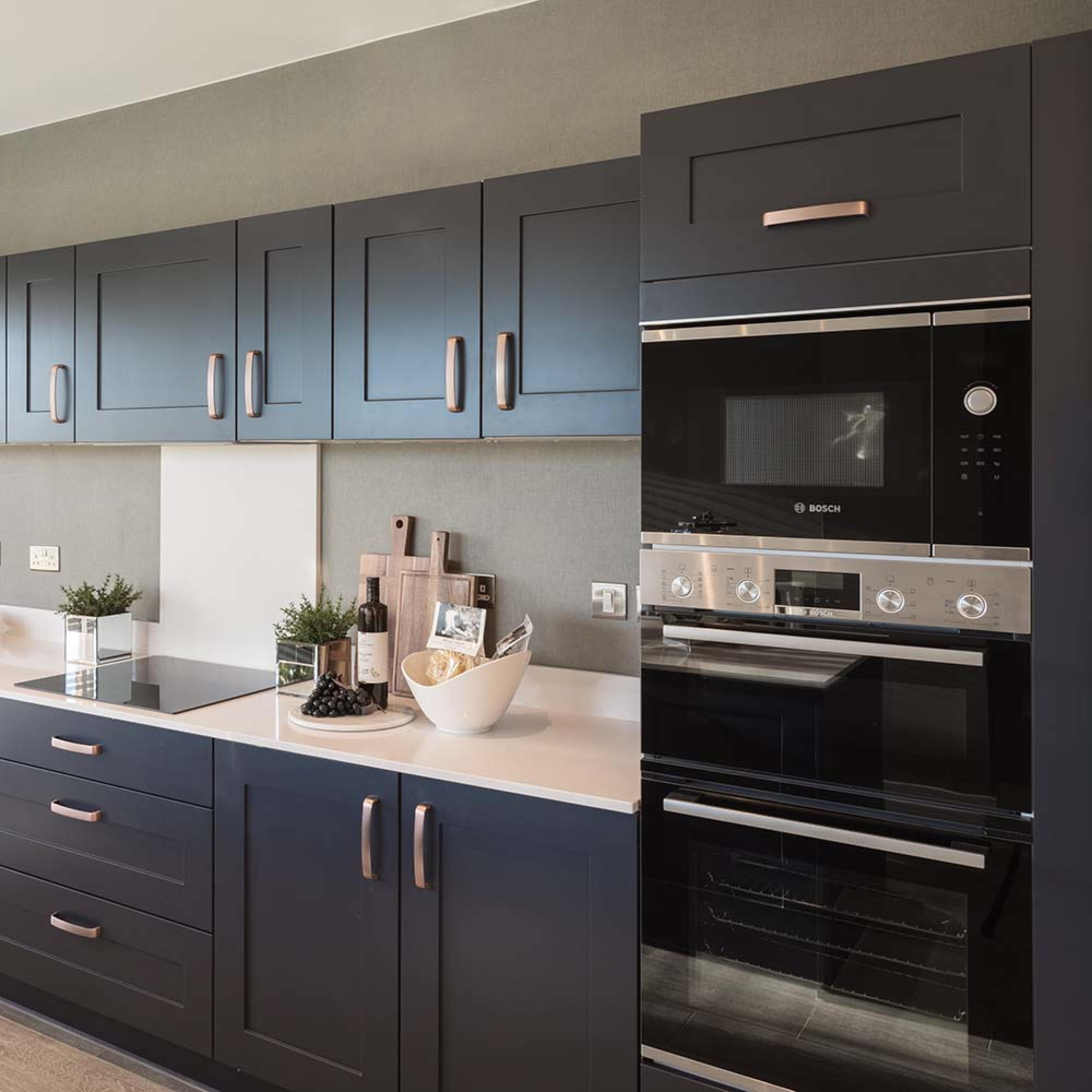 persona-homes-specification-kitchen-midshot-bosch-double-oven-blue-units-white-worktops