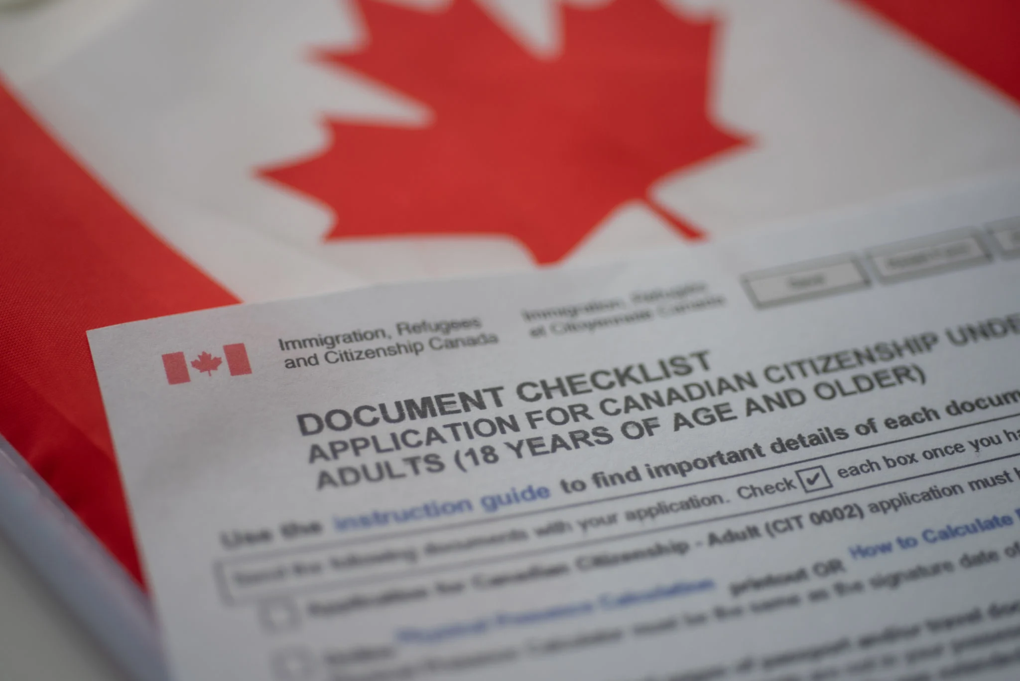 document-check-list-application-for-canadian-citizenship-next-to-canadian-flag-close-up-view.jpg