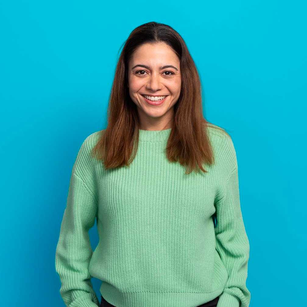 Woman smiling at camera on blue background (top block)