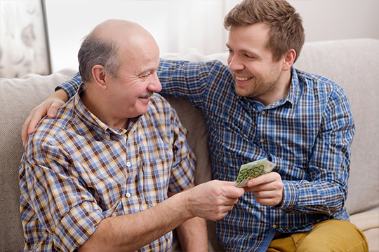 A dad handing his son money