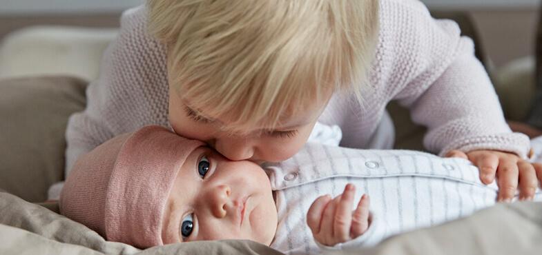 sibling kissing sister