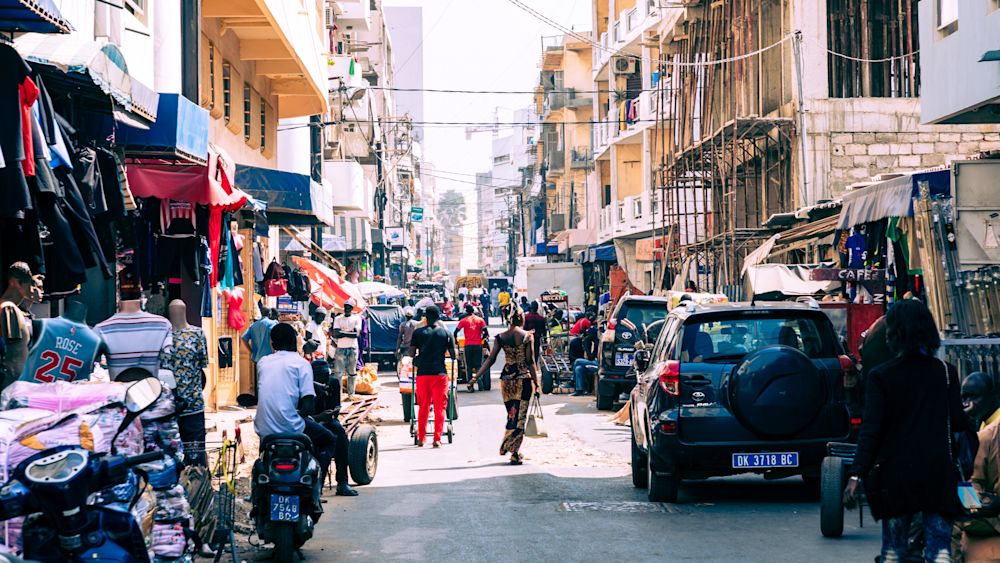 People working and traffic at Senegal capital Dakar, West Africa. Image courtesy of Shutterstock.