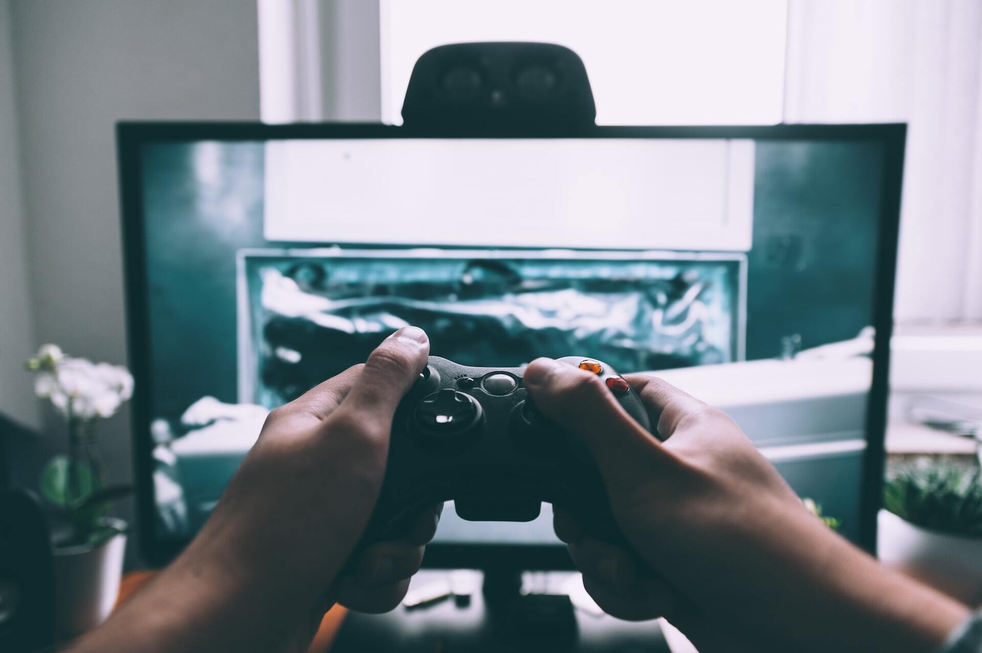 third-person view of a person holding a controller for a gaming device. 
