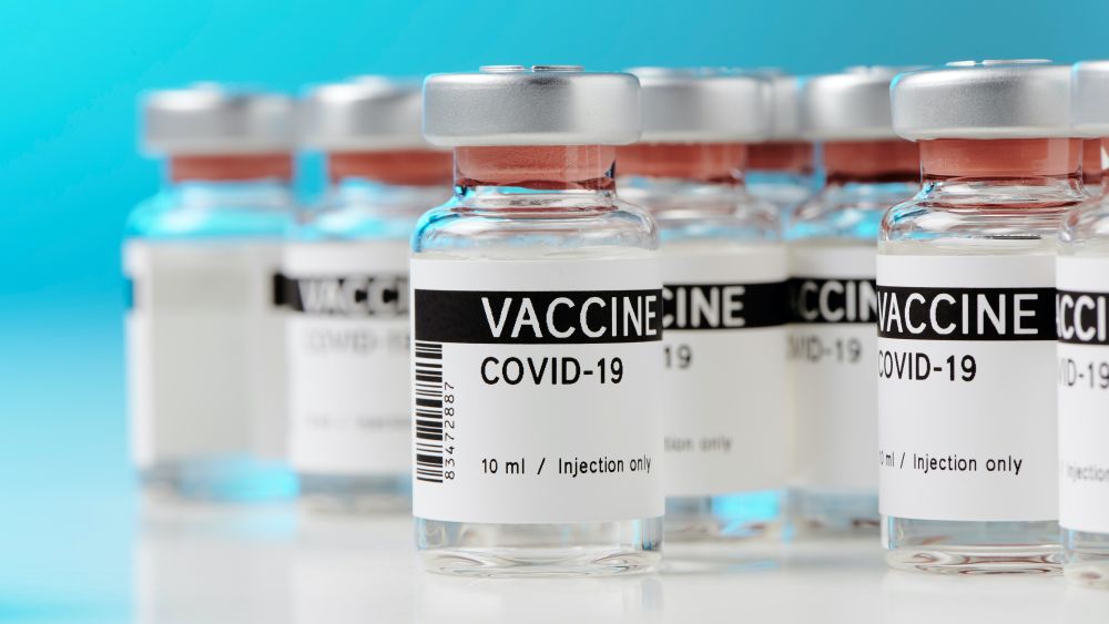 Ampoules with the Covid-19 vaccine on a laboratory bench. Editorial Credit: M-Foto, Shutterstock.