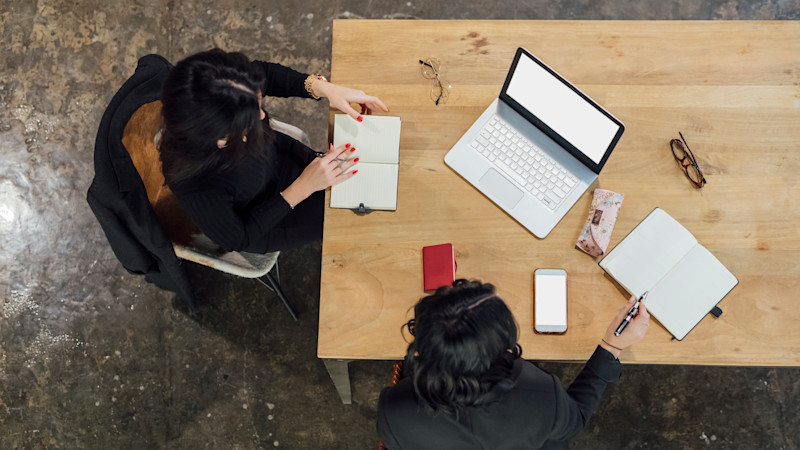 Two women at a table with a laptop