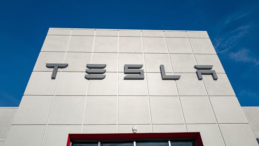 Low-angle view of the facade of Tesla Motors dealership with logo and sign in Pleasanton, California, July 23, 2018. Credit: Smith Collection for Getty Images. 