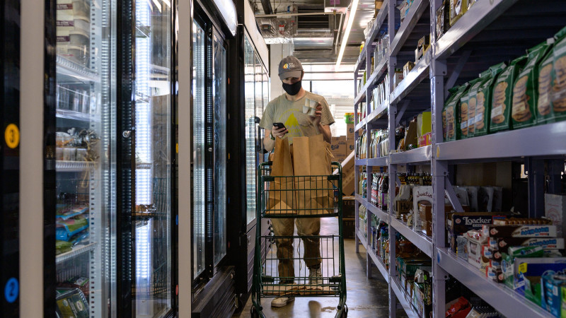 An employee gathers grocery items for delivery