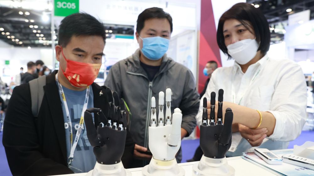 BEIJING, CHINA - OCTOBER 15: A staff member (R) introduces intelligent bionic hands at the Care And Rehabilitation Expo China 2021 on Beijing, China. (Photo by Chen Xiaogen/VCG via Getty Images)