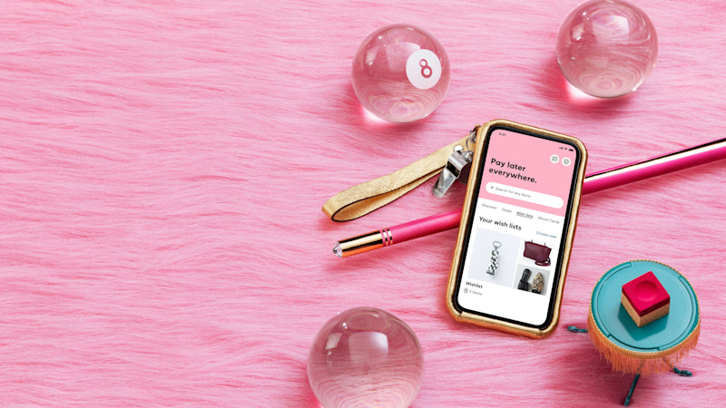 Klarna app on smartphone against pink background