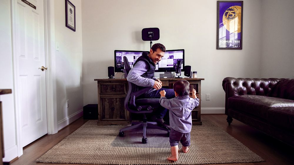 Darren Murph, with a little help from his son, works in his home office in North Carolina. Courtesy of Darren Murph.