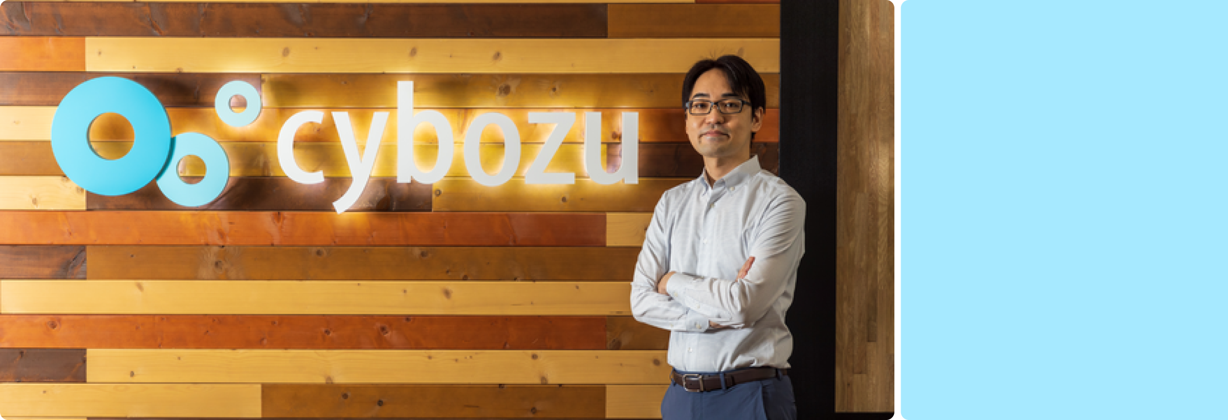Shuichi Suzuki standing in front of Cybozu sign