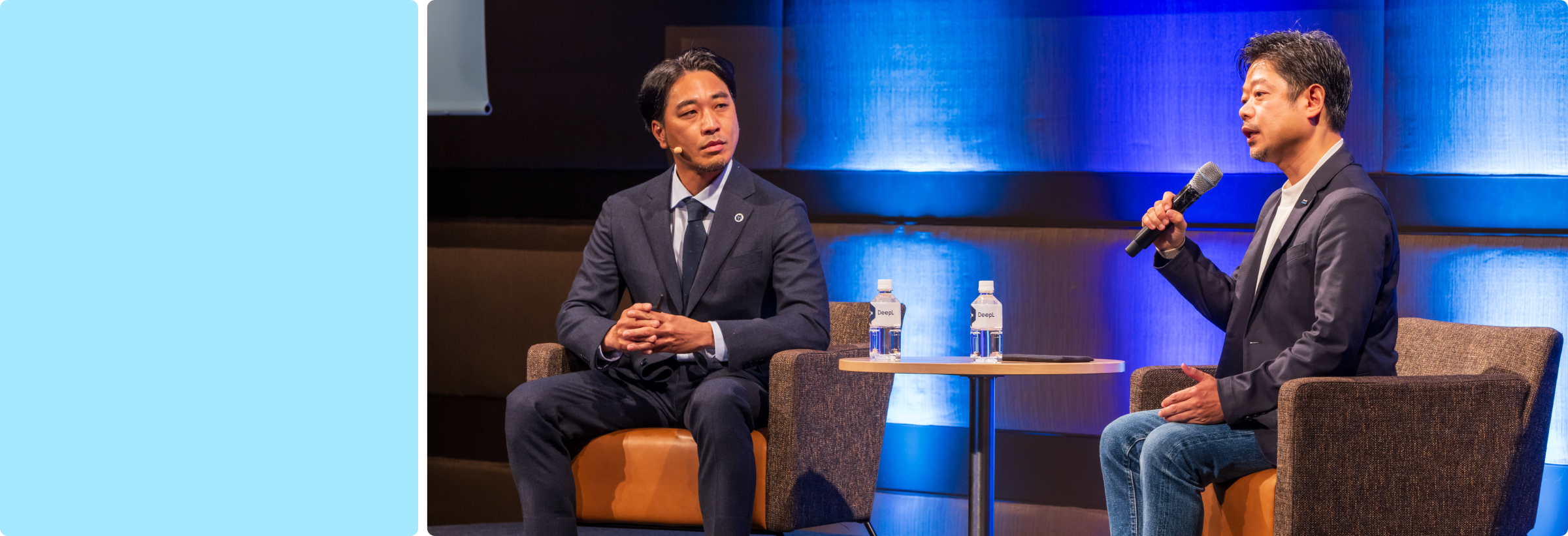 Two men sitting on a stage and having a conversation