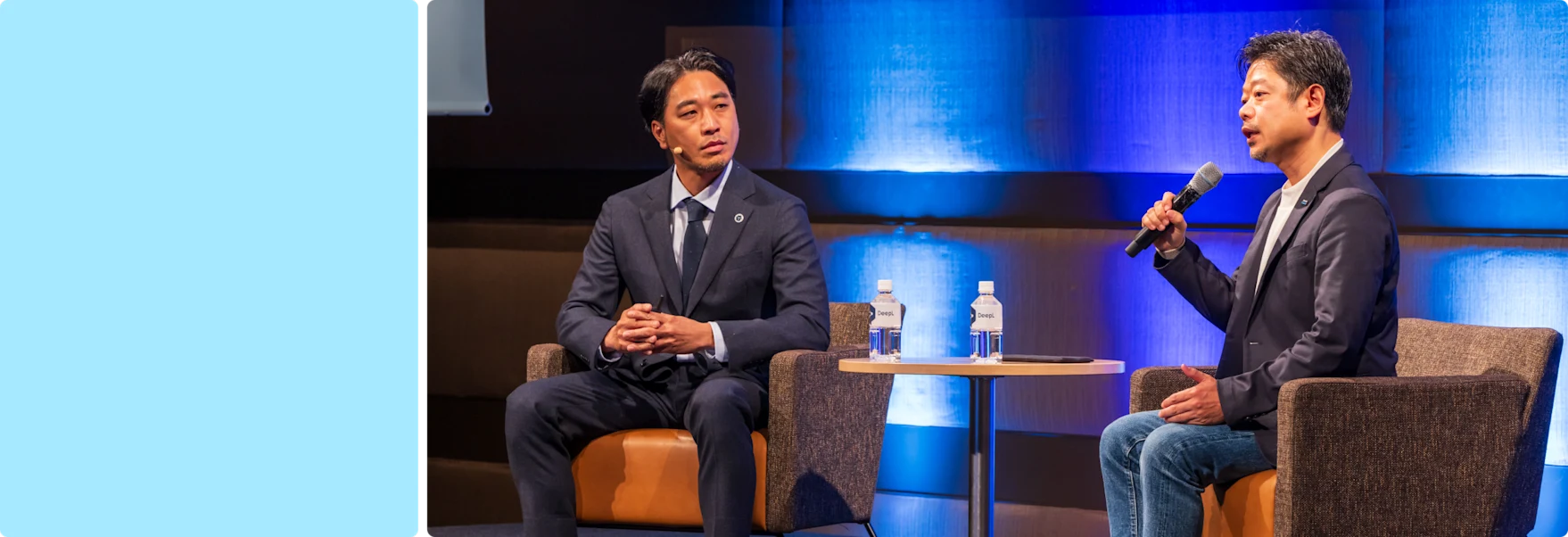 Two men sitting on a stage and having a conversation