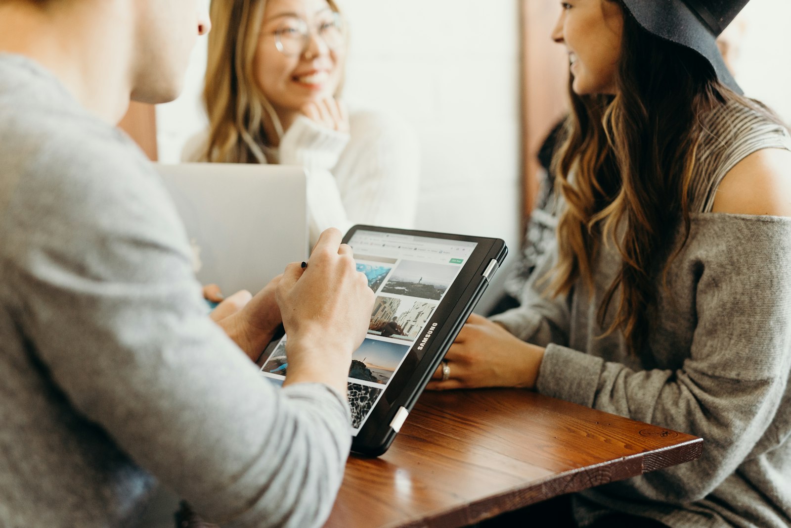 Marketing team collaborating on cited-newsletter strategy with laptops and documents spread across modern office conference table