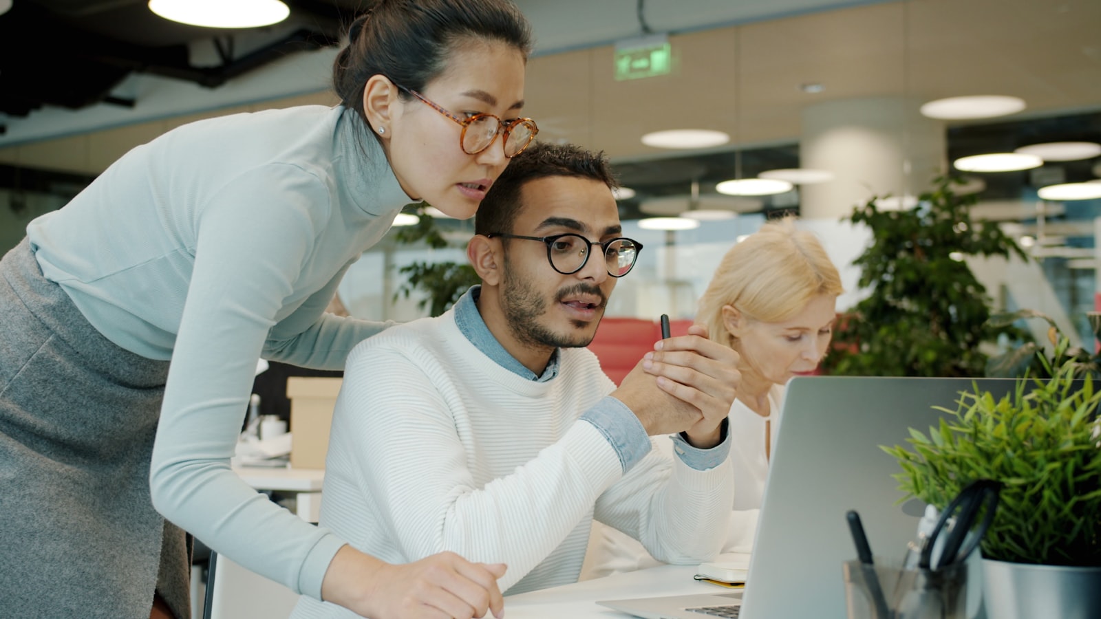 Business team collaborating over laptop displaying automated marketing workflows for lifestyle brand scaling with task management interface