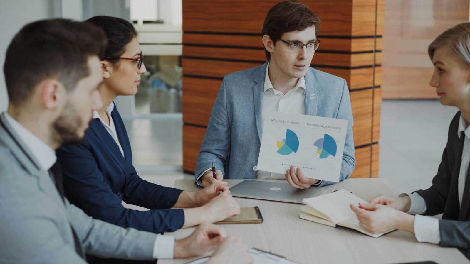 Business professionals in meeting room discussing Copy.ai alternative options with digital screens showing software comparisons
