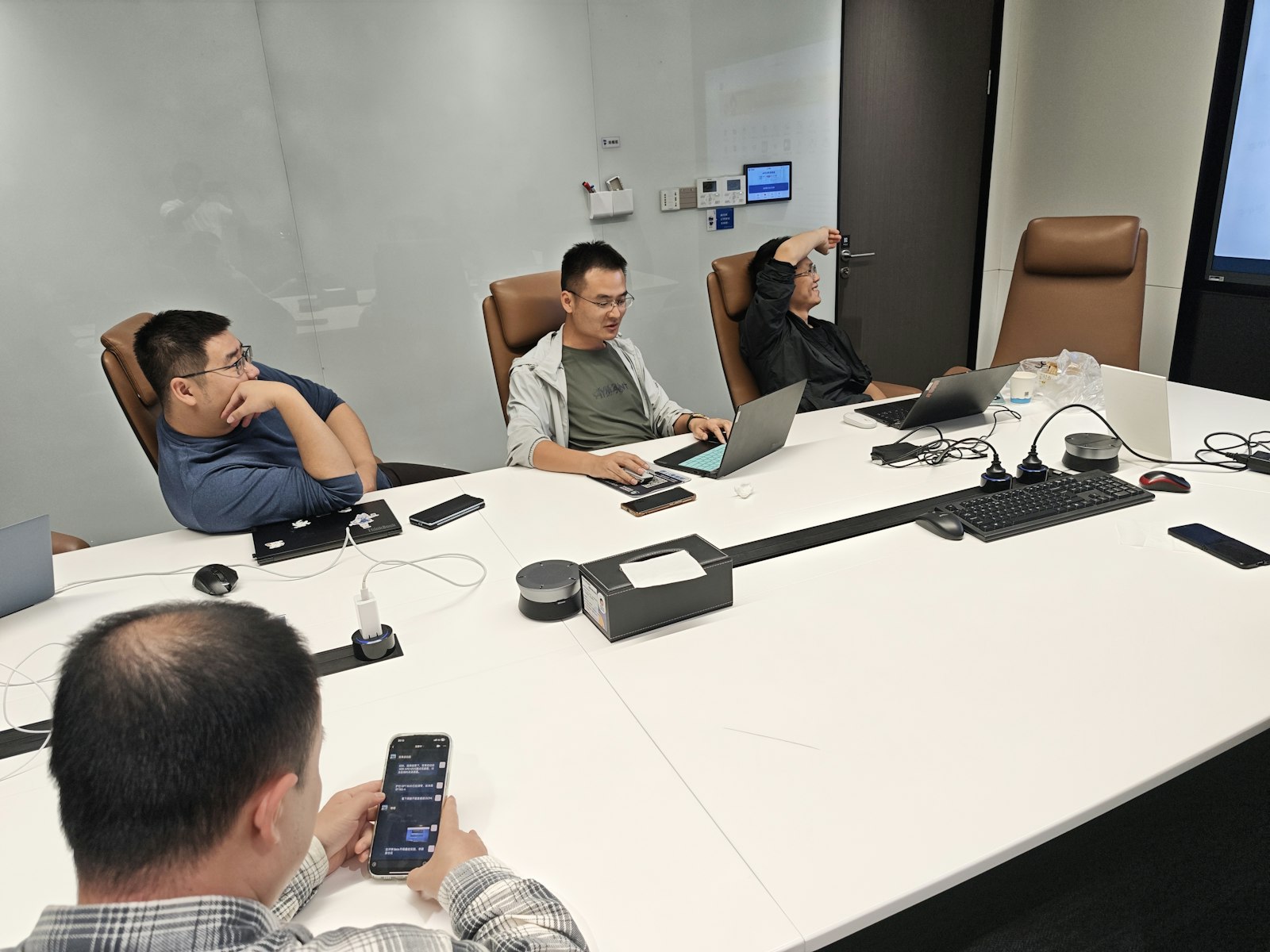 SaaS founders and marketing team discussing AI visibility tools worth it investment during strategic planning meeting with laptops