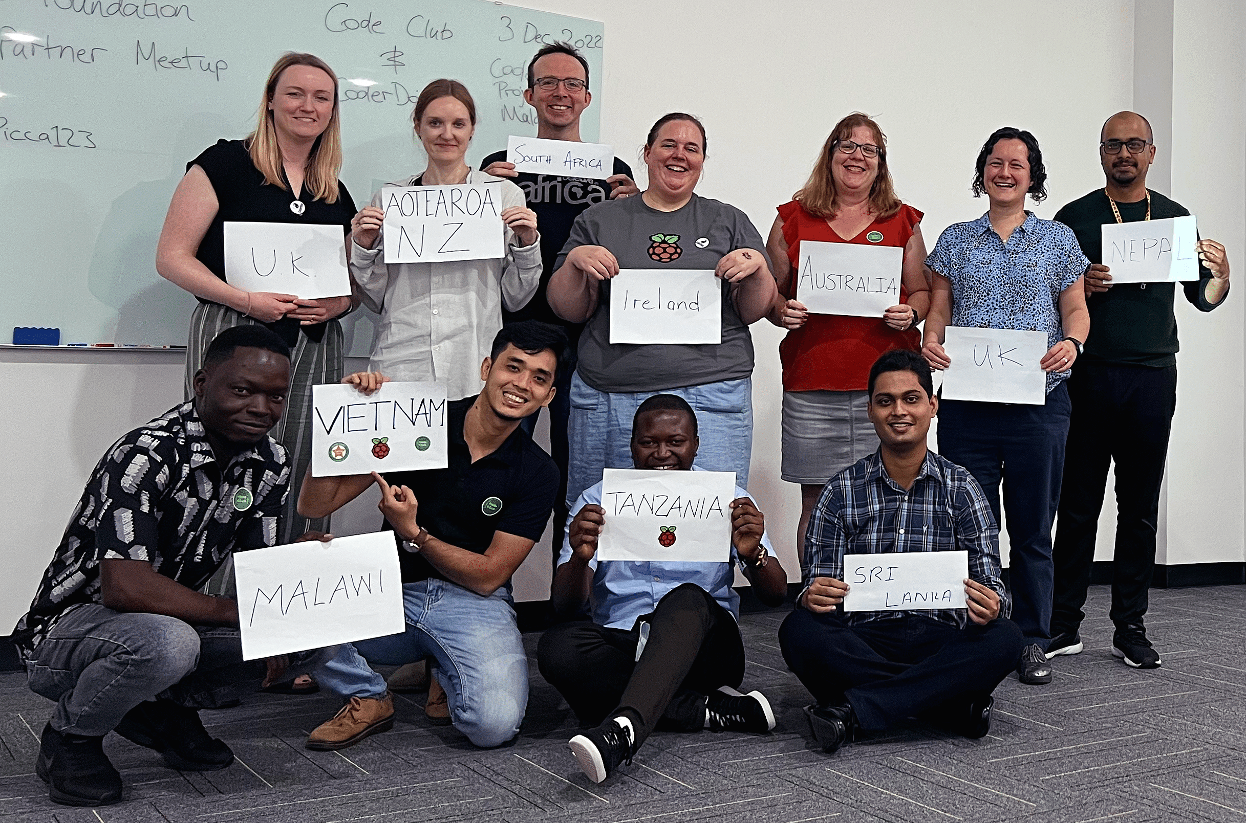 Growth partners from across the world stand together holding signs which share the countries they represent