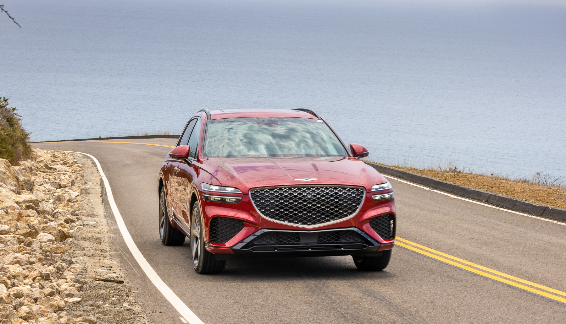 a Genesis GV70 driving near a lake