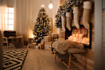 Holiday home setting with Christmas tree and stockings and candles in the fireplace