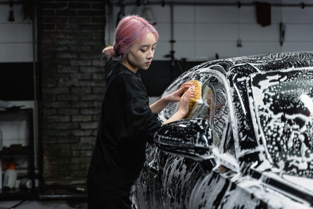 A woman cleaning her car