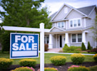 White home with blue for sale sign out front