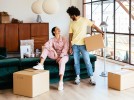 Man and woman with moving boxes in a furnished apartment