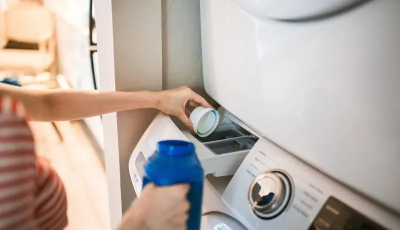 Wasmiddel in een wasmachine lade gieten