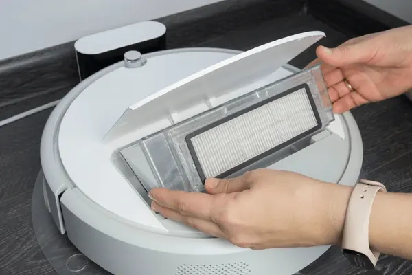 inserts-new-filter-into-vacuum-600nw-1913969536