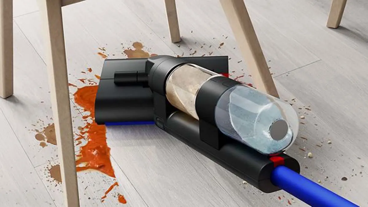 Een gebruiker verwijdert met de Dyson WashG1 elektrische dweil een grote hoeveelheid voedselresten onder een eetkamerstoel