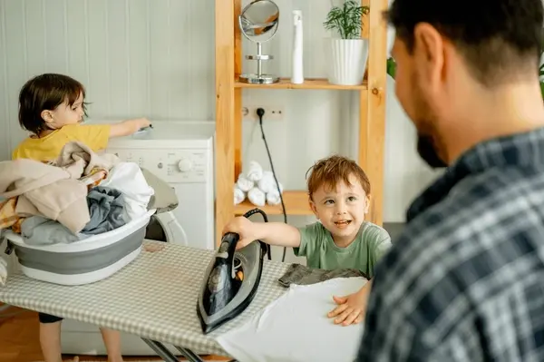 father-son-ironing-clothes-home-600nw-2317794449