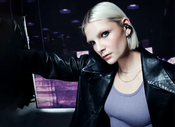 Une femme portant des écouteurs oreilles libres Bose Ultra.
