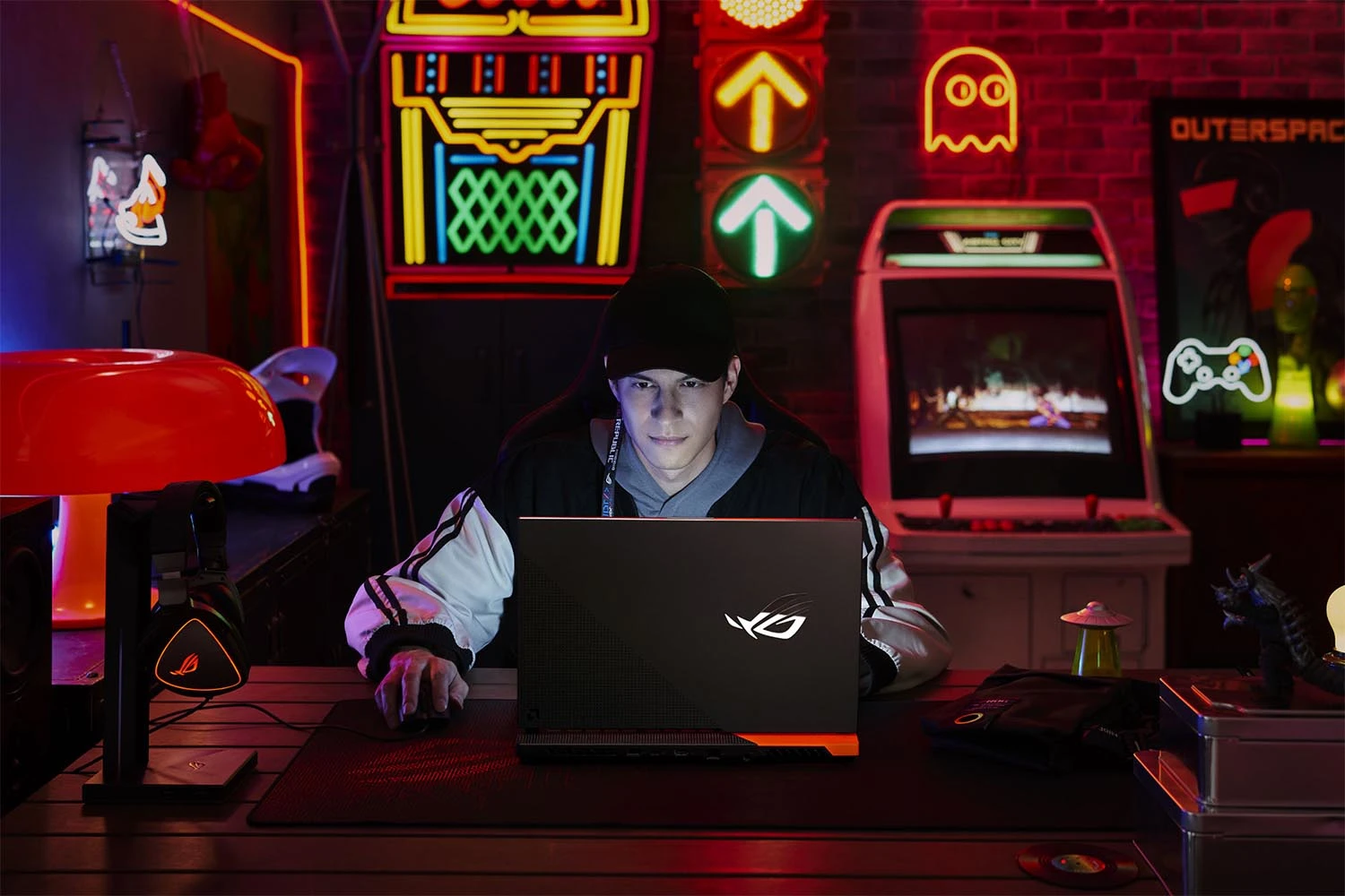 A man playing in front of his Asus ROG gamer laptop.