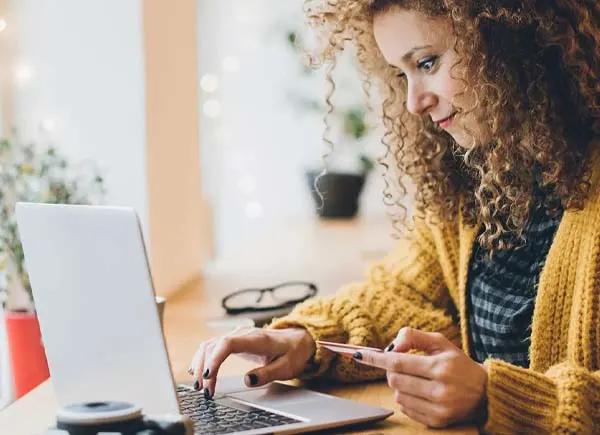 A woman sitting at a table using a laptop.